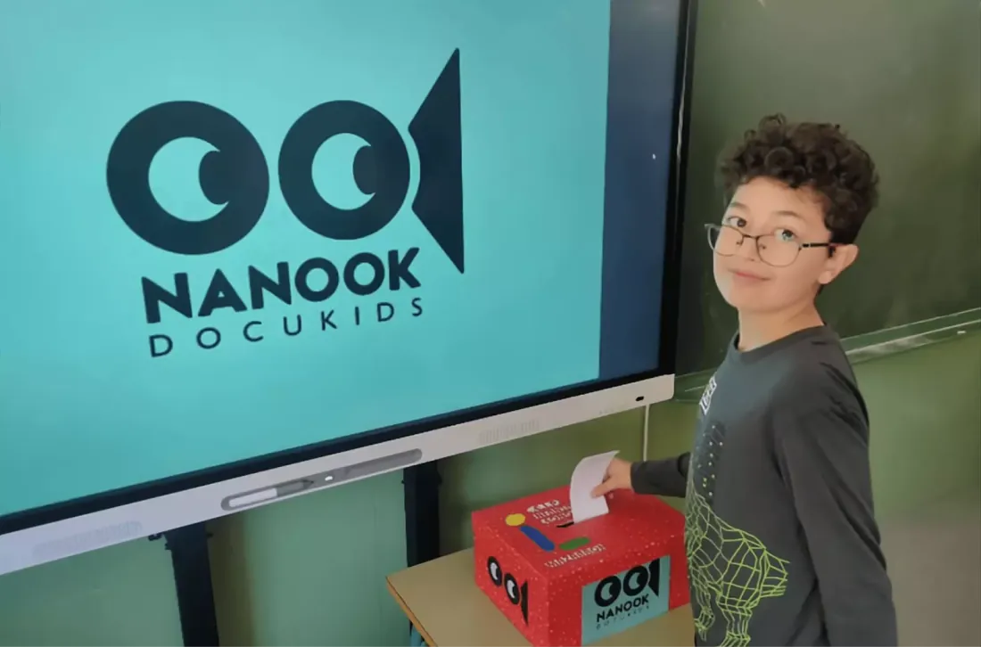 Niño de cara votando en el aula